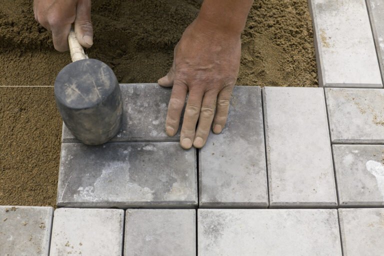 Hands,Of,A,Manual,Worker,Laying,Concrete,Paving,Blocks.
